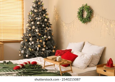 Beautiful mistletoe wreath on beige wall in decorated for Christmas celebration bedroom - Powered by Shutterstock