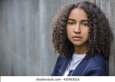 Beautiful mixed race biracial African American girl teenager female young woman outside looking sad depressed or thoughtful