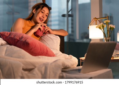 Beautiful Mixed Race Woman Watching Series On Laptop Computer At Home Night Time.