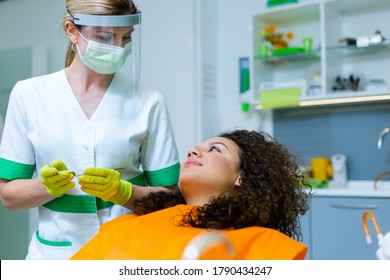 Beautiful Mixed-race Teenage Girl On Dental Checkup By Middle-age Caucasian Woman. Corona Virus Safety Precaution At Dentist's Office. 