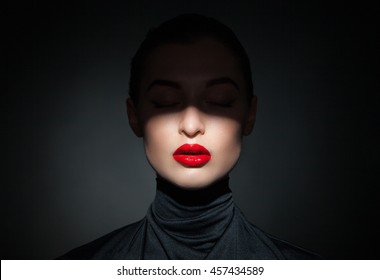 Beautiful Model With Bright Red Lips And Face Half Covered In Shadow