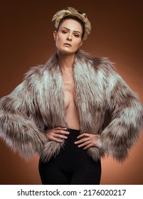 Beautiful Model With Confident Expression Wears An Open Fur Coat, Sexy Winter Style. Brown Background