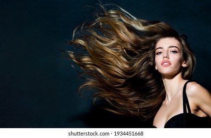 Beautiful Model With Curly Hairstyle. Portrait Of A Beautiful Woman With A Long Hair. Young Brunette Model With Beautiful Hair - Isolated On Black Background. Young Girl With Hair Flying In The Wind