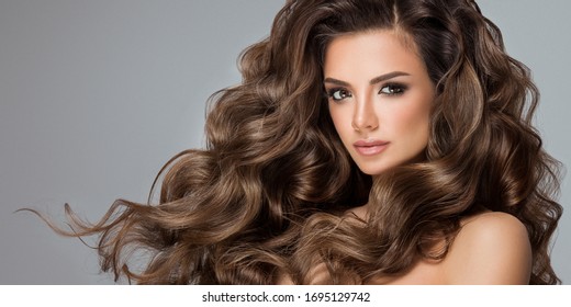 Beautiful Model Girl With Long Wavy And Shiny Hair . Brunette Woman With Curly Hairstyle