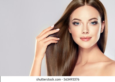Beautiful model girl with shiny brown straight long  hair . Care and hair products .