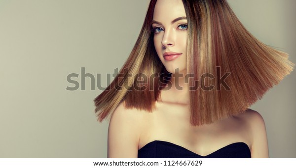 Beautiful model girl with shiny brown and straight long \
hair . Keratin  straightening . Treatment, care and spa procedures.\
Medium length hairstyle. Coloring, ombre, shatush, balage and\
highlighting 