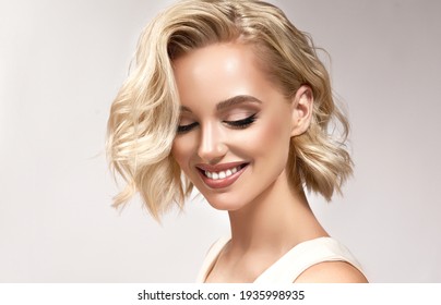Beautiful model girl with short hair .Beauty  smiling woman with blonde curly hairstyle dye .Fashion, cosmetics and makeup - Shutterstock ID 1935998935