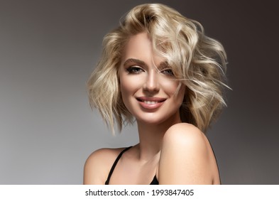 Beautiful model girl with short hair .Beauty woman with blonde curly hairstyle dye .Fashion, cosmetics and makeup