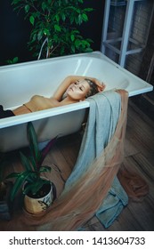 Beautiful model is posing in a bathroom with creative silver makeup