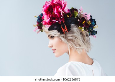 Beautiful Model Posing In Flower Wreath With Butterfly, Isolated On Grey