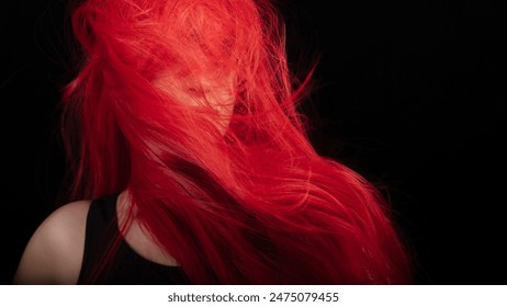 Beautiful model showcasing vibrant red dyed hair in motion against a black background. Isolated with copy space. - Powered by Shutterstock