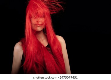 Beautiful model with vibrant red dyed hair posing gracefully against a black background, conveying beauty and hair care concepts. - Powered by Shutterstock