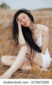 Beautiful Model Wearing Summer Cotton Dress Posing In Autumn Field With Hay Stack. Boho Style Clothing.