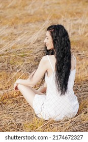 Beautiful Model Wearing Summer Cotton Dress Posing In Autumn Field With Hay Stack. Boho Style Clothing.