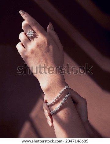 beautiful model wearing white gold diamond ring and tinnes bracelets.