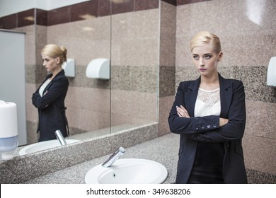 Beautiful Model Woman Businesswoman In Business Attire In The Mirror In The Bathroom