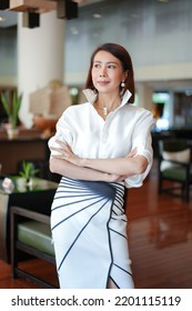 Beautiful Model Woman In White Dress In Modern Corporate Building Lobby.