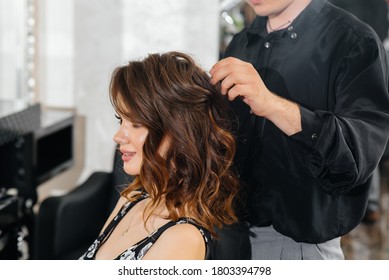 In a beautiful, modern beauty salon, a professional stylist makes a haircut and hairstyle for a young girl. Beauty, and fashion - Powered by Shutterstock