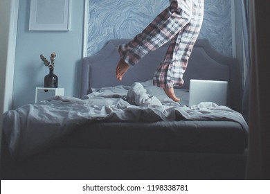 beautiful modern bedroom in blue pastel colors, morning bed, legs of a jumping girl in pajamas, conceptual fly mood photo. quarantined house. waiting for a free pandemic to end. remote work at home - Shutterstock ID 1198338781
