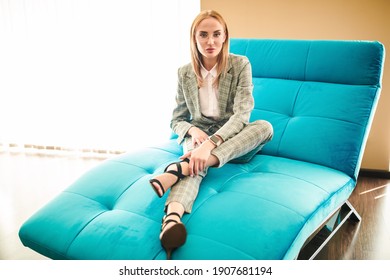 Beautiful modern business lady resting at home on the couch. Modern interior and furniture. - Shutterstock ID 1907681194