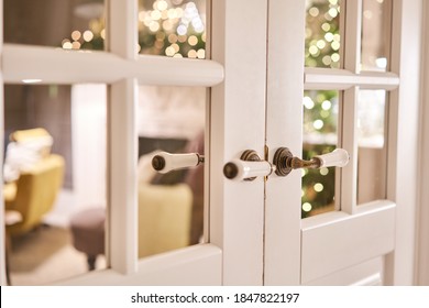 Beautiful Modern Door Knob. Christmas Lights On The Background. Open, Wooden Front Door From The Interior Of An Upscale Home With Windows.