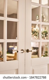 Beautiful Modern Door Knob. Christmas Lights On The Background. Open, Wooden Front Door From The Interior Of An Upscale Home With Windows.