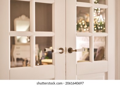 Beautiful Modern Door Knob. Christmas Lights On The Background. Open, Wooden Front Door From The Interior Of An Upscale Home With Windows.