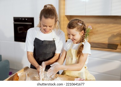 In The Beautiful Modern Kitchen Adorable Young Motheer Teaching Small Schooler Kid Knead Dough With Hands Preparing Homemade Cookies Bakery. Having Fun Together Talking.