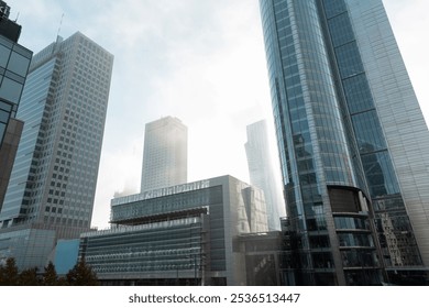 Beautiful modern metropolis in the fog with business and office buildings and the Palace of Culture in Warsaw. Amazing foggy city of Warsaw with sun, Poland on a cloudy, overcast day. Urban wallpaper  - Powered by Shutterstock