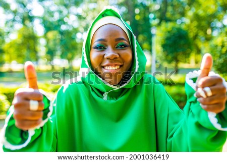Beautiful modern student woman in hijab with make-up and piercing ring on the nose outdoor