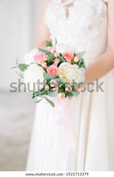 Beautiful modern wedding bouquet in the hands of\
the bride.
