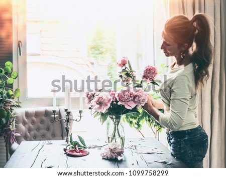 Similar – Woman with peonies on table in the living room