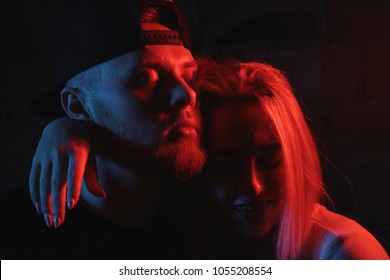 Beautiful Modern Young Couple Hugging In A Neon Light Red And Blue Lamp