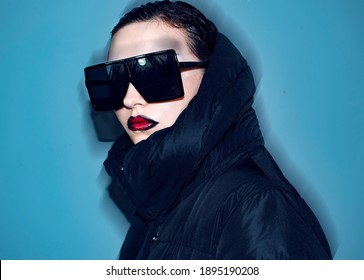 Beautiful modern young woman portrait in studio wearing black winter jacket black sunglasses   red gradient lipstick glamour