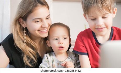 Beautiful Mom With Her Children At Home Durin A Video Call On Computer. Happy Family Enjoying Facetime Conversation. 