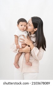 Beautiful  mom  holding  and kissing her baby girl baby cheek with love and care on isolated background. Concept of relationship between mother and child. - Shutterstock ID 2103678089