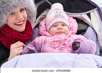 Beautiful Mom And Nice Baby Outdor In A Winter Day