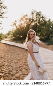 Beautiful Mom In The Park, In A Summer Dress. Loose Hair And Open Arms. Summer Walk. 