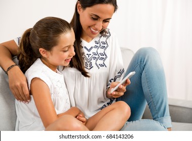 Beautiful Mom Showing To Her Daughter Something On Her Phone