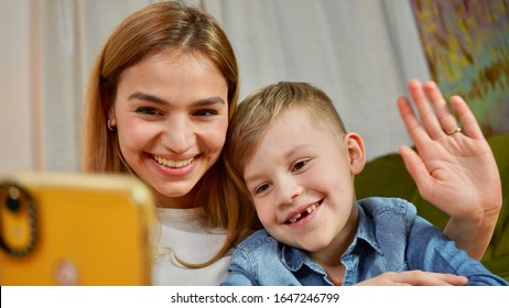 Beautiful mom and son making selfie at home. Happy family having a facetime video call. Unity, connection, technology concept