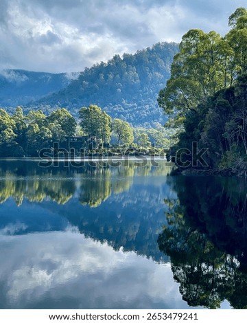 Beautiful but moody cloud and forest reflections on Lake Rosebery in Tasmania, Australia