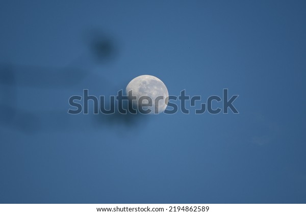 beautiful moon\
in the middle of the blue sky at\
dusk