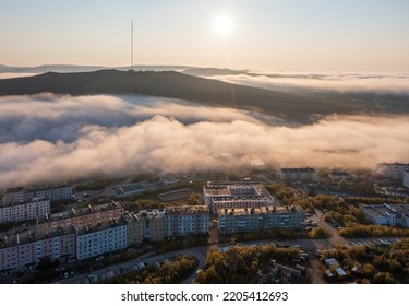 Beautiful Morning Cityscape. Aerial View Of Buildings In The Valley Among The Hills. Low Clouds. TV Tower On The Top Of The Mountain. Sunrise Over The City Of Magadan, Magadan Region, Siberia, Russia.