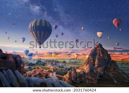 Beautiful morning hot air balloon flight against the backdrop of a starry sky over spectacular Cappadocia, Turkey.