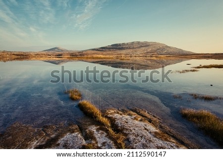 Beautiful morning landscape scenery with mountains reflected in Lake at Burren National Park in county Clare, Ireland 