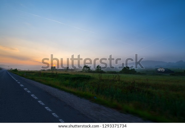 Beautiful\
morning on road. Sun is rising in mountains. Concept of road trip\
and traveling with car  around Europe,\
Romania