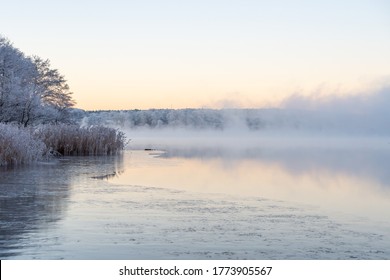 Beautiful morning at sunrise, dawn, the fog swirls around the early winter landscape. The mist, sunshine and lake create a dreamy scene. Misty blue yellow background with place for text, copy space.