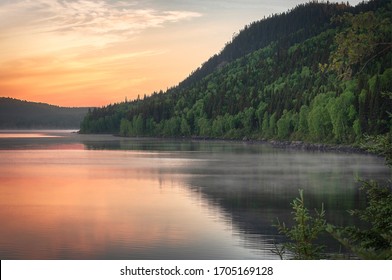 Beautiful Morning Sunrise on a Steamy Lake Surrounded by Mountains With Trees in Quebec Canada - Powered by Shutterstock