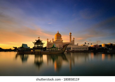 Beautiful mosque with golden dome and ship monument in long exposure during sunset
