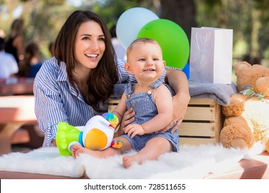 Beautiful Mother With Baby Infant Child With Big Gorgeous Smile And Adorable Expression At Family Gathering